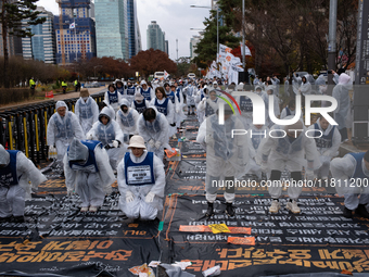 Members of the Korea Parents' Network for People with Disabilities perform the symbolic 'five-body prostration' protest in front of the Nati...