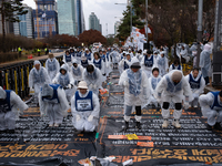 Members of the Korea Parents' Network for People with Disabilities perform the symbolic 'five-body prostration' protest in front of the Nati...