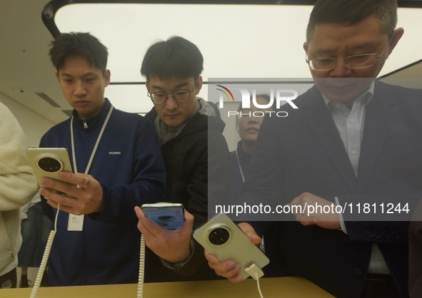 Customers experience the newly released Mate70 series mobile phone at a Huawei store in Hangzhou, Zhejiang province, China, on November 26,...