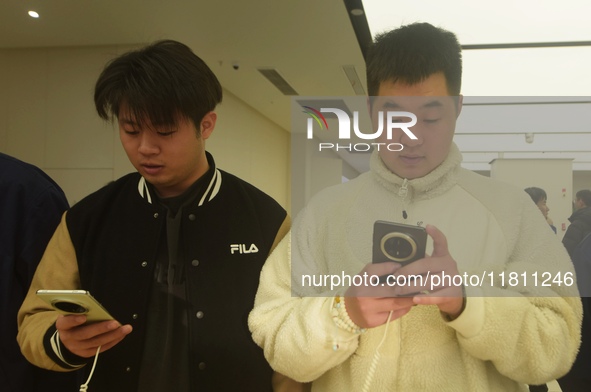 Customers experience the newly released Mate70 series mobile phone at a Huawei store in Hangzhou, Zhejiang province, China, on November 26,...