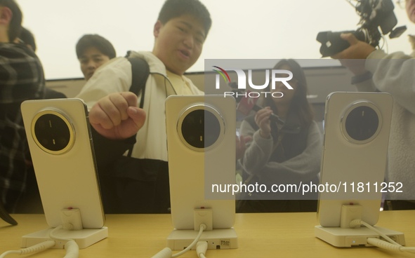 Customers experience the newly released Mate70 series mobile phone at a Huawei store in Hangzhou, Zhejiang province, China, on November 26,...