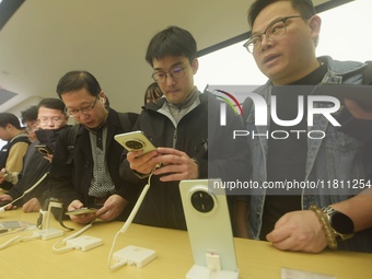 Customers experience the newly released Mate70 series mobile phone at a Huawei store in Hangzhou, Zhejiang province, China, on November 26,...