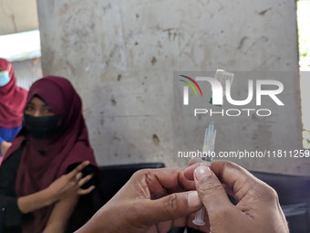 A madrasah student receives the HPV vaccine from a healthcare assistant in Feni, Bangladesh, on November 26, 2024. Bangladesh takes strides...