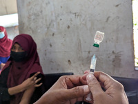 A madrasah student receives the HPV vaccine from a healthcare assistant in Feni, Bangladesh, on November 26, 2024. Bangladesh takes strides...