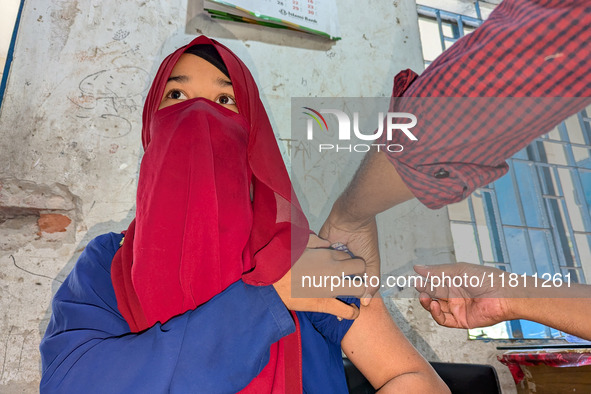 A madrasah student receives the HPV vaccine from a healthcare assistant in Feni, Bangladesh, on November 26, 2024. Bangladesh takes strides...