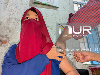 A madrasah student receives the HPV vaccine from a healthcare assistant in Feni, Bangladesh, on November 26, 2024. Bangladesh takes strides...