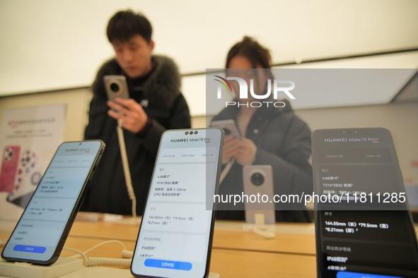 Customers learn about the newly released Huawei Mate70 series mobile phone at a Huawei store in Yantai, China, on November 26, 2024. 