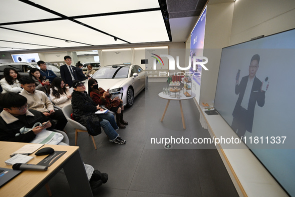 Customers watch the Mate70 new phone launch event at a Huawei store in Nanjing, China, on November 26, 2024. 