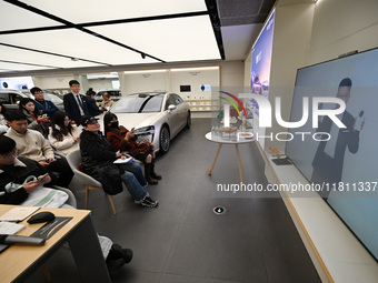 Customers watch the Mate70 new phone launch event at a Huawei store in Nanjing, China, on November 26, 2024. (