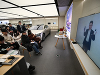 Customers watch the Mate70 new phone launch event at a Huawei store in Nanjing, China, on November 26, 2024. (