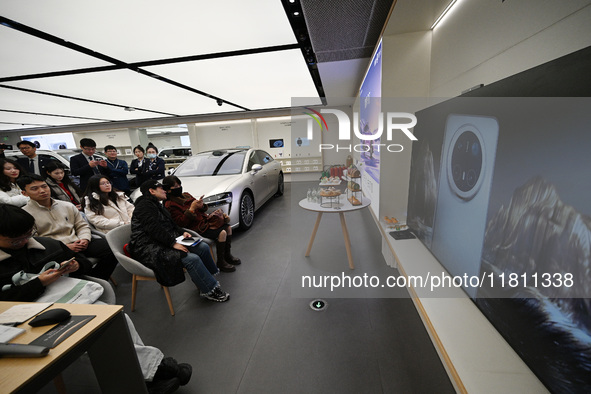 Customers watch the Mate70 new phone launch event at a Huawei store in Nanjing, China, on November 26, 2024. 