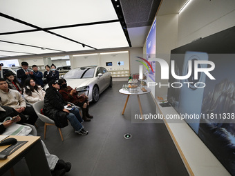 Customers watch the Mate70 new phone launch event at a Huawei store in Nanjing, China, on November 26, 2024. (