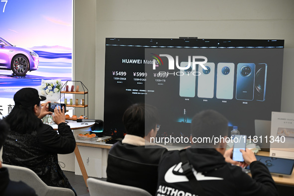 Customers watch the Mate70 new phone launch event at a Huawei store in Nanjing, China, on November 26, 2024. 