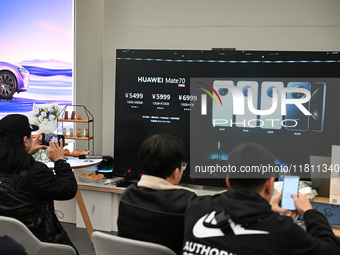 Customers watch the Mate70 new phone launch event at a Huawei store in Nanjing, China, on November 26, 2024. (