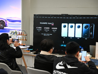 Customers watch the Mate70 new phone launch event at a Huawei store in Nanjing, China, on November 26, 2024. (