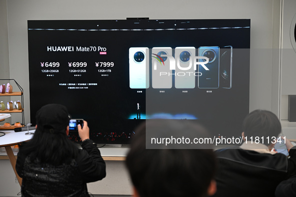 Customers watch the Mate70 new phone launch event at a Huawei store in Nanjing, China, on November 26, 2024. 