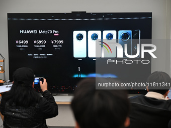 Customers watch the Mate70 new phone launch event at a Huawei store in Nanjing, China, on November 26, 2024. (