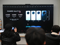 Customers watch the Mate70 new phone launch event at a Huawei store in Nanjing, China, on November 26, 2024. (