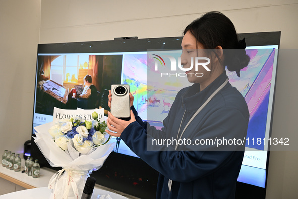 A Huawei employee displays the Mate70 phone in Nanjing, China, on November 26, 2024. 