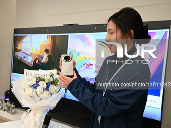 A Huawei employee displays the Mate70 phone in Nanjing, China, on November 26, 2024. (