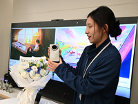 A Huawei employee displays the Mate70 phone in Nanjing, China, on November 26, 2024. (