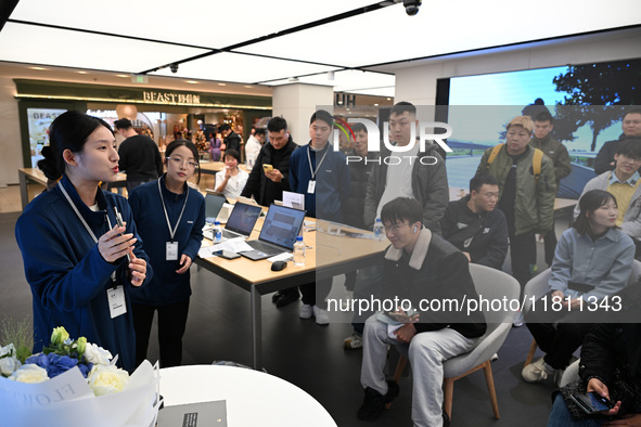 A Huawei employee displays the Mate70 phone in Nanjing, China, on November 26, 2024. 