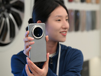 A Huawei employee displays the Mate70 phone in Nanjing, China, on November 26, 2024. (