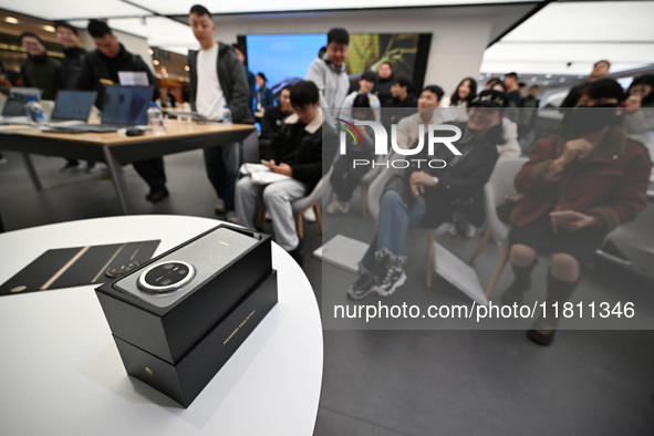 Customers experience the newly released Huawei Mate70 phone at a Huawei store in Nanjing, China, on November 26, 2024. 