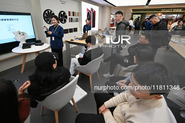 Customers experience the newly released Huawei Mate70 phone at a Huawei store in Nanjing, China, on November 26, 2024. 