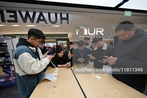 Customers experience the newly released Huawei Mate70 phone at a Huawei store in Nanjing, China, on November 26, 2024. 