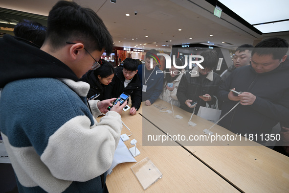 Customers experience the newly released Huawei Mate70 phone at a Huawei store in Nanjing, China, on November 26, 2024. 