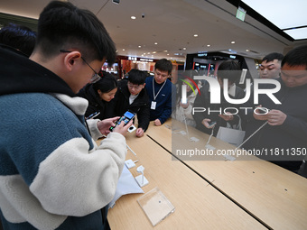 Customers experience the newly released Huawei Mate70 phone at a Huawei store in Nanjing, China, on November 26, 2024. (