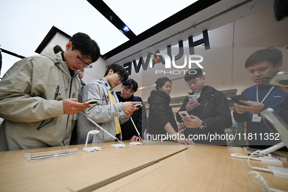 Customers experience the newly released Huawei Mate70 phone at a Huawei store in Nanjing, China, on November 26, 2024. 