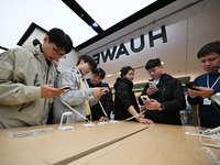 Customers experience the newly released Huawei Mate70 phone at a Huawei store in Nanjing, China, on November 26, 2024. (