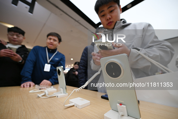 Customers experience the newly released Huawei Mate70 phone at a Huawei store in Nanjing, China, on November 26, 2024. 