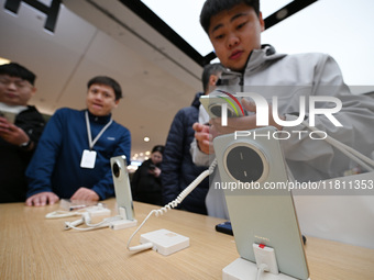 Customers experience the newly released Huawei Mate70 phone at a Huawei store in Nanjing, China, on November 26, 2024. (