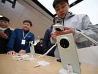 Customers experience the newly released Huawei Mate70 phone at a Huawei store in Nanjing, China, on November 26, 2024. (