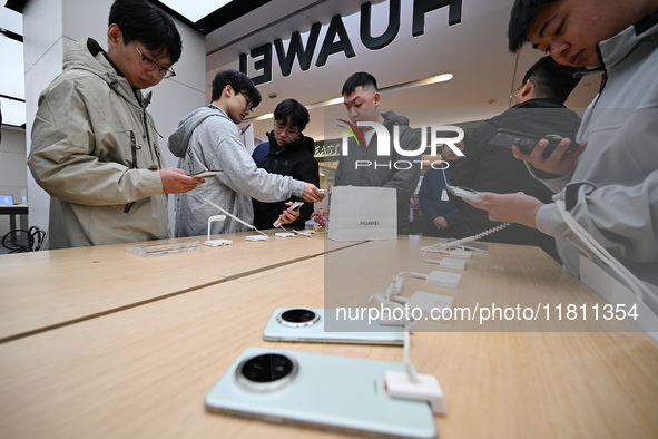 Customers experience the newly released Huawei Mate70 phone at a Huawei store in Nanjing, China, on November 26, 2024. 