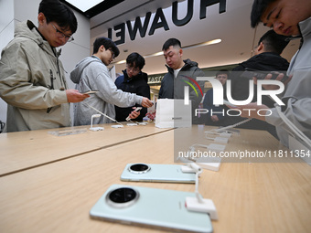 Customers experience the newly released Huawei Mate70 phone at a Huawei store in Nanjing, China, on November 26, 2024. (