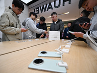 Customers experience the newly released Huawei Mate70 phone at a Huawei store in Nanjing, China, on November 26, 2024. (