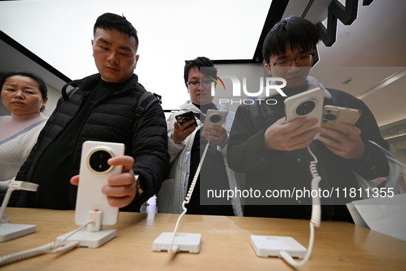 Customers experience the newly released Huawei Mate70 phone at a Huawei store in Nanjing, China, on November 26, 2024. 