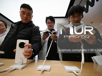 Customers experience the newly released Huawei Mate70 phone at a Huawei store in Nanjing, China, on November 26, 2024. (