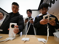 Customers experience the newly released Huawei Mate70 phone at a Huawei store in Nanjing, China, on November 26, 2024. (