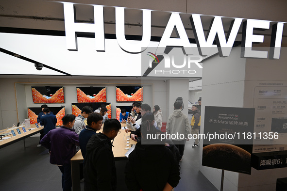 Customers experience the newly released Huawei Mate70 phone at a Huawei store in Nanjing, China, on November 26, 2024. 