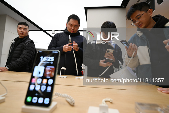 Customers experience the newly released Huawei Mate70 phone at a Huawei store in Nanjing, China, on November 26, 2024. 