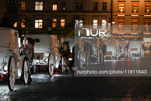 KRAKOW, POLAND - NOVEMBER 21:   
Horse-drawn carriages waiting for tourists at Krakow's Main Market Square, on November 21, 2024 in Krakow,...