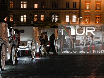 KRAKOW, POLAND - NOVEMBER 21:   
Horse-drawn carriages waiting for tourists at Krakow's Main Market Square, on November 21, 2024 in Krakow,...