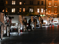 KRAKOW, POLAND - NOVEMBER 21:   
Horse-drawn carriages waiting for tourists at Krakow's Main Market Square, on November 21, 2024 in Krakow,...