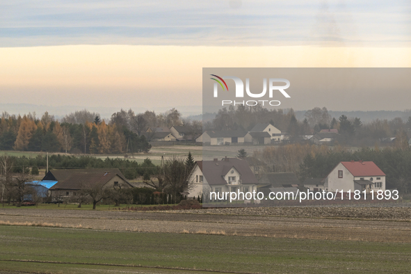 KRAKOW, POLAND - NOVEMBER 19:   
A small village with frozen fields and trees losing their leaves, seen from a train window as winter approa...