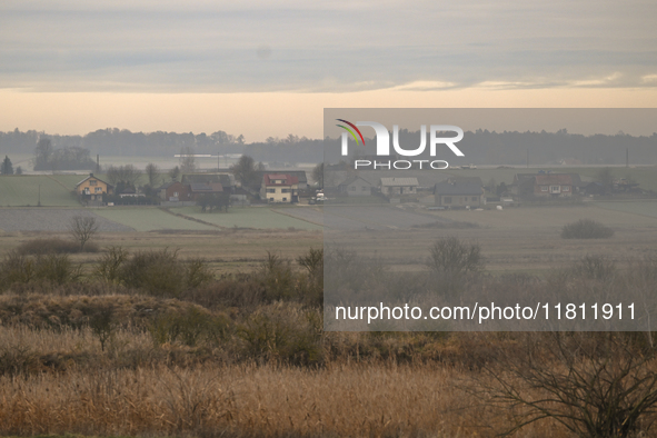 KRAKOW, POLAND - NOVEMBER 19:   
A small village with frozen fields and trees losing their leaves, seen from a train window as winter approa...